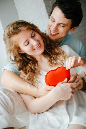 Couple in love watches a gift heart box on Valentines day.の写真素材