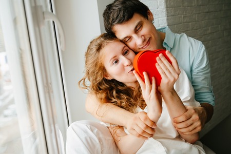 Couple in love watches a gift heart box on Valentines day.の写真素材
