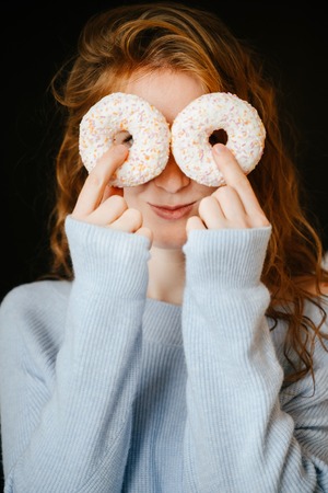 Portrait of a redhead girl and donuts.の写真素材