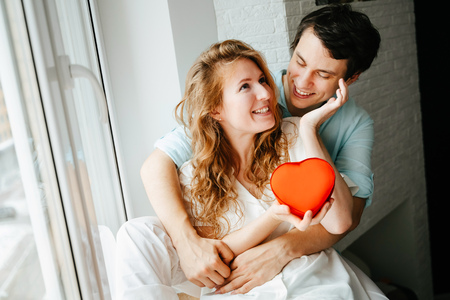 Couple in love watches a gift heart box on Valentines day.の写真素材