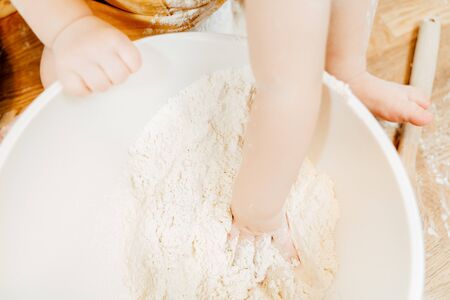 Top view childrens hands stir flour sit at tableの写真素材