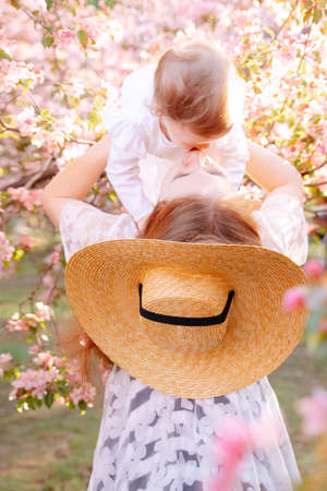 Joyful mother enjoying happy family time with cute toddler girl and lifting her in the air in nature park.Mothers Day.の写真素材