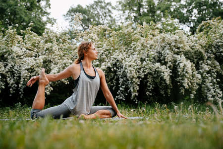 Young sportive woman in leggings performs yoga exercises in the fresh air.Sports banner horizontal...