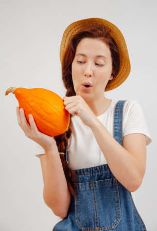 Woman farmer checks the autumn harvest of pumpkins for ripeness. Concept of agriculture.の写真素材