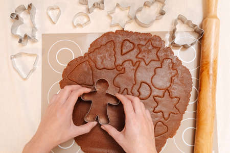 Cooking Christmas gingerbread from dough using metal molds top view. Concept of Christmas and New Year traditions.の写真素材