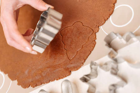 Traditional holiday and family biscuits are sliced raw gingerbread cookies in a metal spruce shape.の写真素材