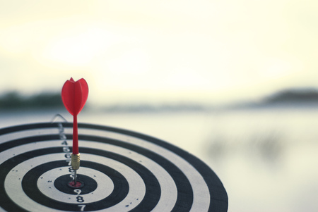 Shot red dart arrow in center of dartboard. Concept to target success and winner..