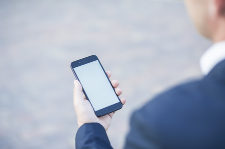Touch screen of a mobile phone, in the hand of a businessman. Photo for Mock Up.の写真素材