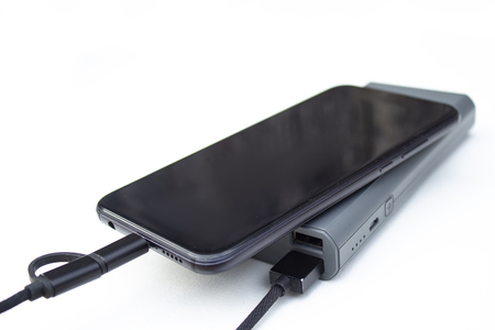 Portable charging gadgets. Smartphone with power bank on a white background.