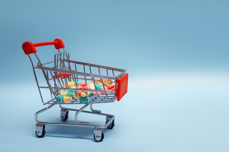 Concept on the topic of health. Tablets and capsules in a trolley for a supermarketの写真素材