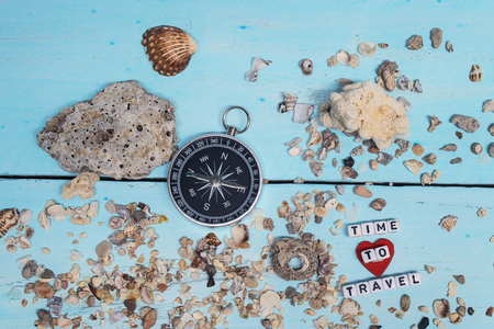 Time to Travel. Idea for tourism with compass on the sand with corals on the wooden backgroundの写真素材