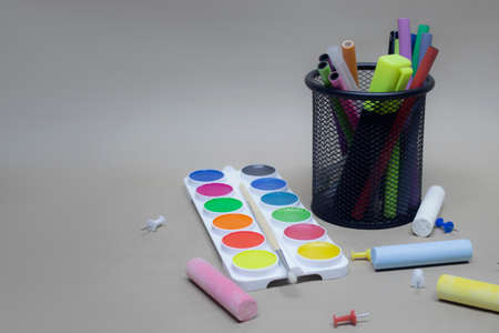 Back to school background. Paints for painting and stationery in the basket
