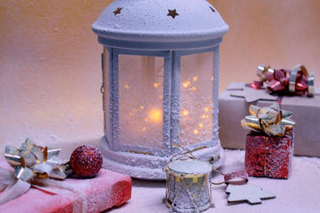 Festive concept for Christmas and New Year. A beautiful decorative lamp glows on a snowy background...