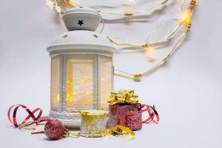 Christmas and New Year composition. Festive glowing lantern with decorations, gifts and bright bows...