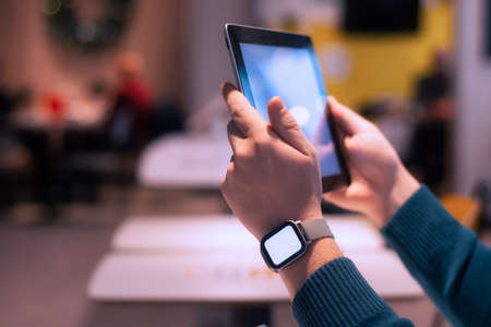 Businessman with smart watch and digital tablet with a white screen in his hands. A male freelancer...