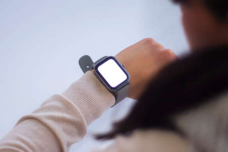 Female with a smartwatch and a white screen mockup on his hand. Man uses fitness tracker isolated on...