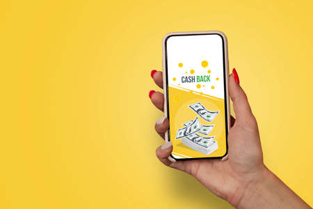 Girl with beautiful nails holds smartphone with banner Cash Backの写真素材