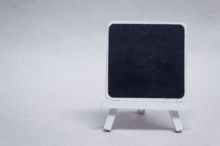 Mock-up black chalk board made of wood for inscription, on a light backgroundの写真素材