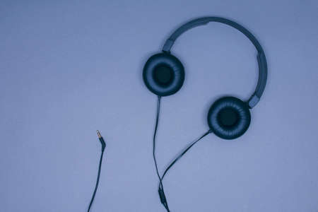 Large black musical headphones with a wire on a gray backgroundの写真素材