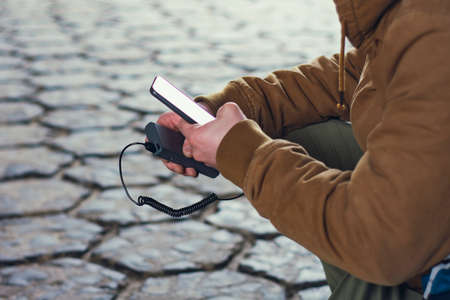 People is holding a portable charger with a smartphone in his handの写真素材