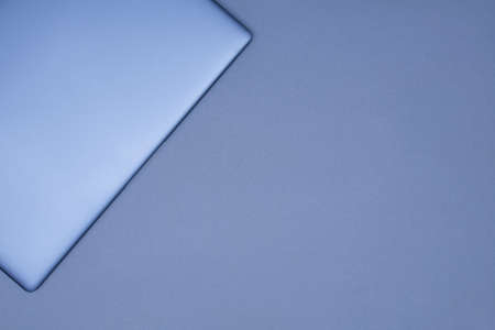 Closed silver laptop on a gray background. Top view