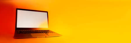 Slim modern laptop with white screen Mockup set against bright, red creative lightの写真素材