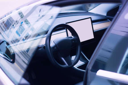 Interior of a modern car. Photo of a car interior with a mockup of a tablet with a white screenの写真素材