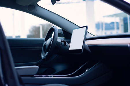 Interior of a modern car. Photo of a car interior with a mockup of a tablet with a white screenの写真素材