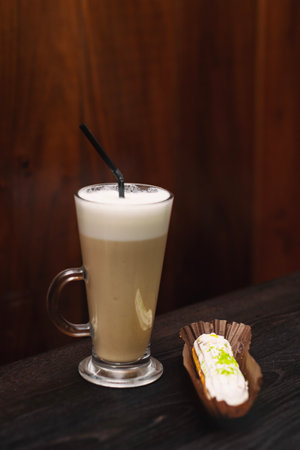 Coffee latte with chocolate cheesecake in a coffee shop on a wooden tableの写真素材