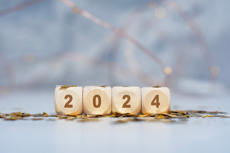 New Year holiday background. Inscription on wooden cubes of the number 2024 with bright glowing lightsの写真素材