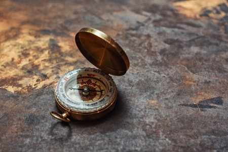 Retro brass compass in large on vintage background. Navigation tool for tourism