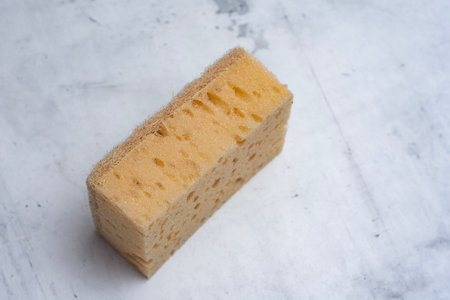 Natural coconut sponge on a marble table. Dishwashing accessory made of natural materials