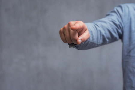 Concept of pointing finger. Close-up of a man in a shirt pointing his finger forward against a...