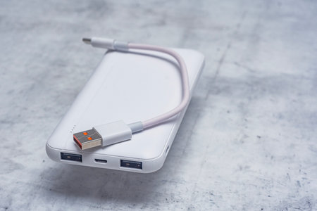 White power bank on a marble table. Portable charger for gadgets