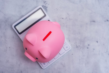 Piggy bank and calculator symbolize saving money and planning for the future. Investing in your future with wise money managementの写真素材