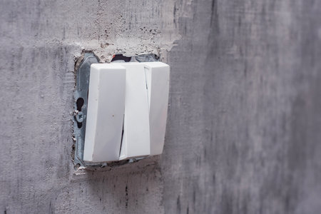 Close-Up of a wall light switch installed during renovation. Light switch mounted on an unfinished wall, representing electrical work in progressの写真素材