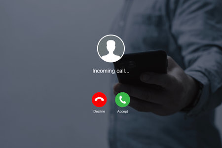 Notification of an incoming call on a smartphone held by a man wearing a shirtの写真素材
