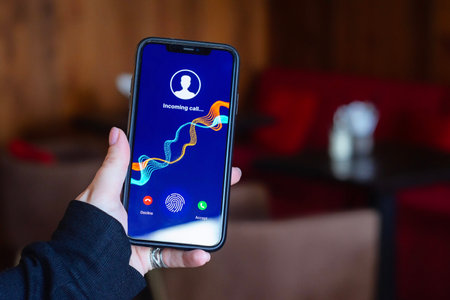 Woman holds smartphone with incoming call in cozy cafeの写真素材