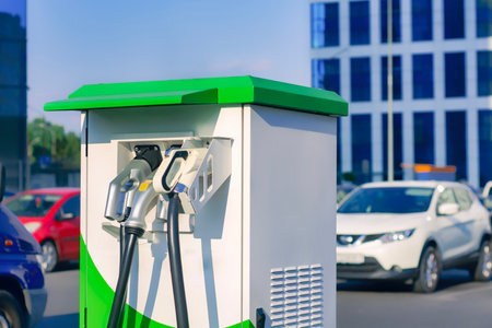 Electronic charging for an electric car. Electric vehicle charging station in the city with cars in the backgroundの写真素材