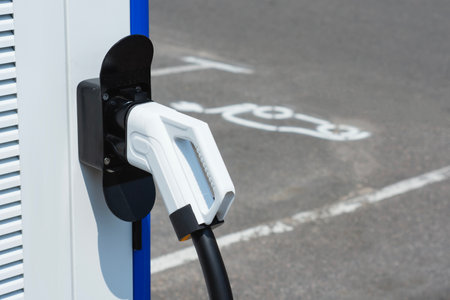 Close-up electric vehicle charging connector plugged into a modern charging station. Concept clean energy, sustainable transportation, and the growing infrastructure for electric carsの写真素材