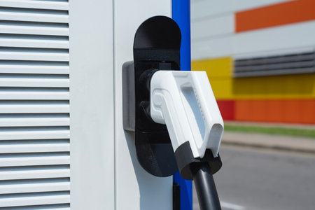 Close-up electric vehicle charging connector plugged into a modern charging station. Concept clean energy, sustainable transportation, and the growing infrastructure for electric carsの写真素材