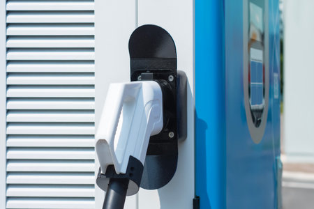 Close-up electric vehicle charging connector plugged into a modern charging station. Concept clean energy, sustainable transportation, and the growing infrastructure for electric carsの写真素材
