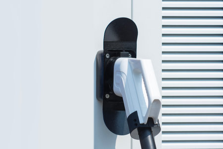 Close-up electric vehicle charging connector plugged into a modern charging station. Concept clean energy, sustainable transportation, and the growing infrastructure for electric carsの写真素材