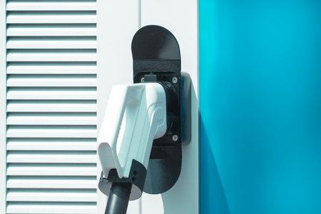 Close-up electric vehicle charging connector plugged into a modern charging station. Concept clean energy, sustainable transportation, and the growing infrastructure for electric carsの写真素材