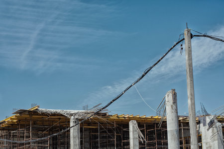Dangerous collapse of concrete formwork on a construction site. Broken supports, bent rebar, and exposed concrete columns. Concept construction site safety and engineering mistakes workplaceの写真素材