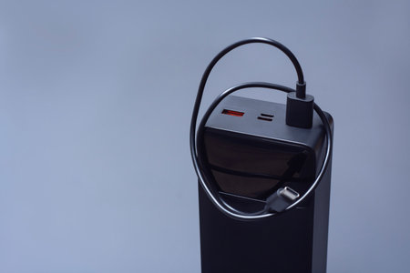 Large portable Power Bank in black with USB-C charging cable on a soft light background. Power source for charging smartphones and devices on the goの写真素材