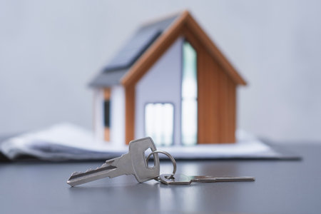 House keys with a model of a modern house with solar panels on the roof. Concept eco-friendly housing and energy efficiencyの写真素材
