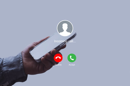 Notification of an incoming call on a smartphone held by a man wearing a shirt. Concept of mobile communication, telecommunication and incoming call notificationの写真素材