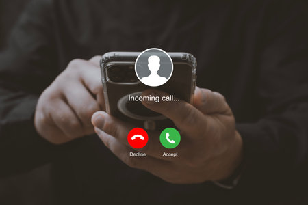 Man holding smartphone with incoming call interface screen. Close-up of hands holding mobile phone with call accept and decline buttons on displayの写真素材