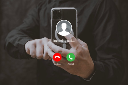 Man holding smartphone with incoming call interface screen. Close-up of hands holding mobile phone with call accept and decline buttons on displayの写真素材